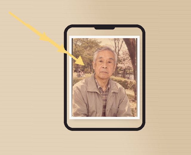 公園で写した白髪の男性の古い写真を平らに置き、窓の光を斜めから当てて、スマホを真上に構えて撮る様子の図（架空の人物の見本）
